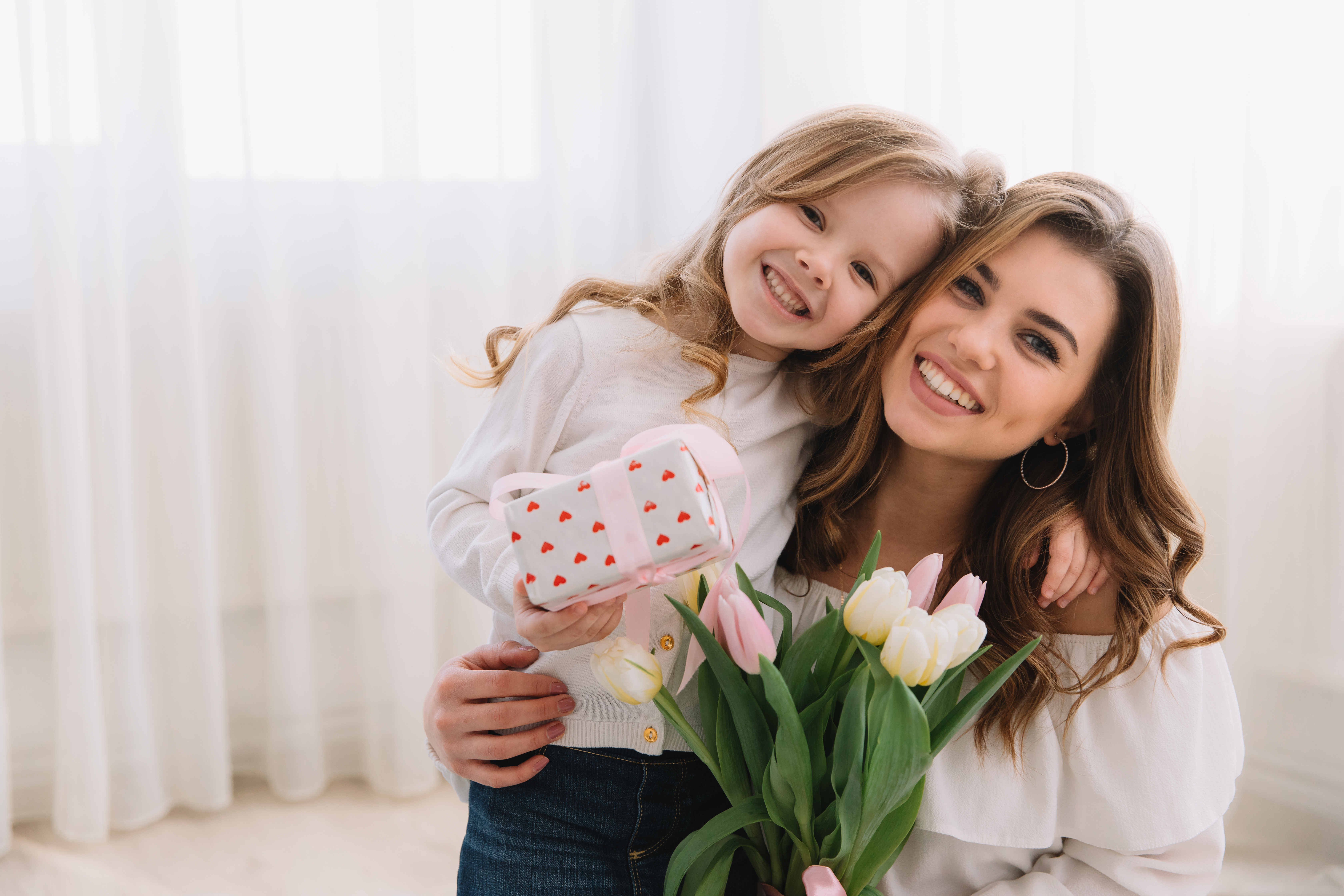 Happy mother’s day. Child daughter congratulates moms and gives